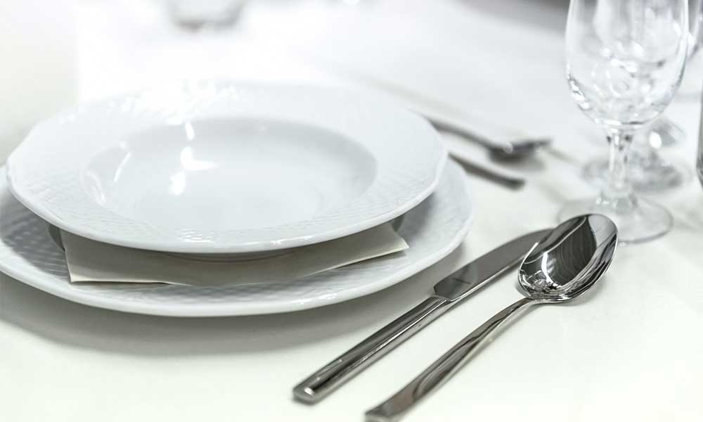 A place setting with a spoon, knife, glass, and plate