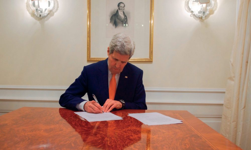 Former Secretary of State John Kerry signs an order to lift sanctions in 2016. (Photo credit: U.S. Department of State)