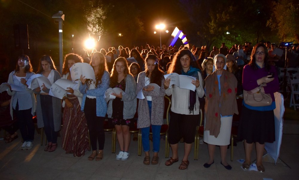 A group of young women pray selihot outside at night in Israel.