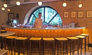 A man stands behind an empty bar at Vermuteria, in Kyiv.
