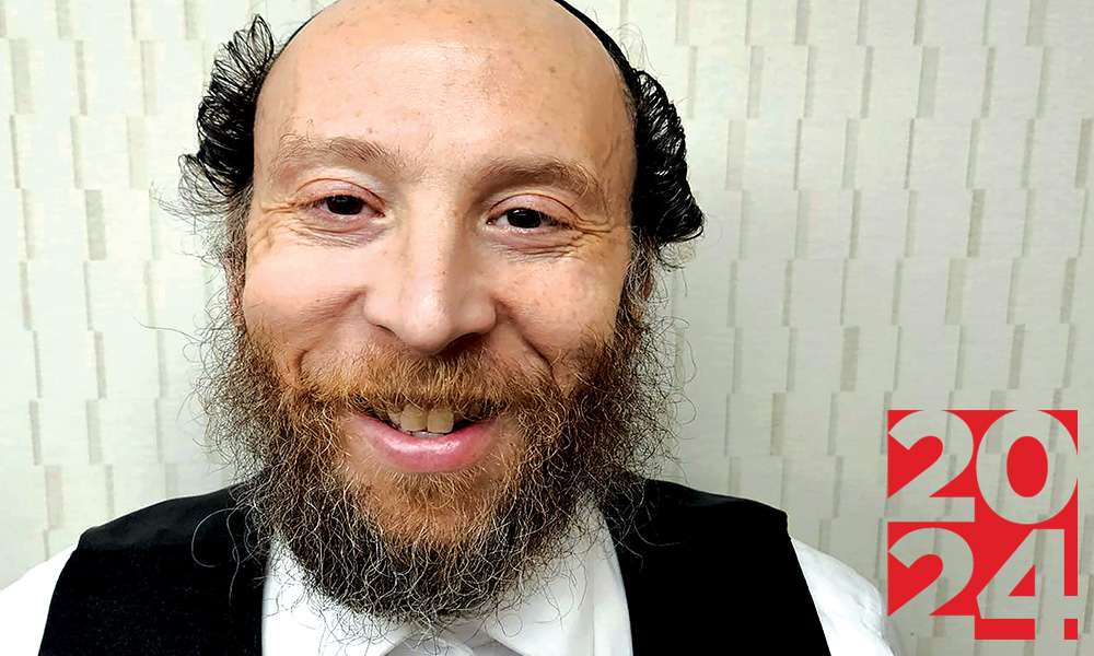 Man with short black hair and beard smiles