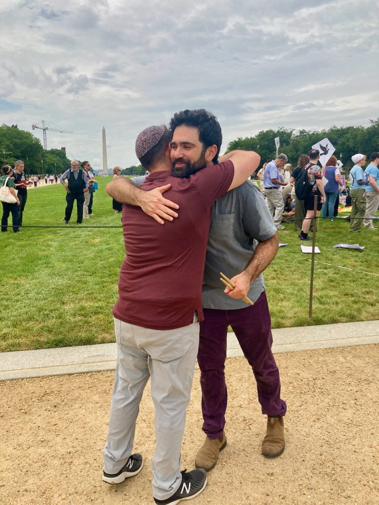 Aaron Shneyer hugs a friend at the at the Peace & Justice Bloc rally