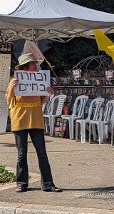 Israeli woman holds sign "Choose Life" on October 7, 2024