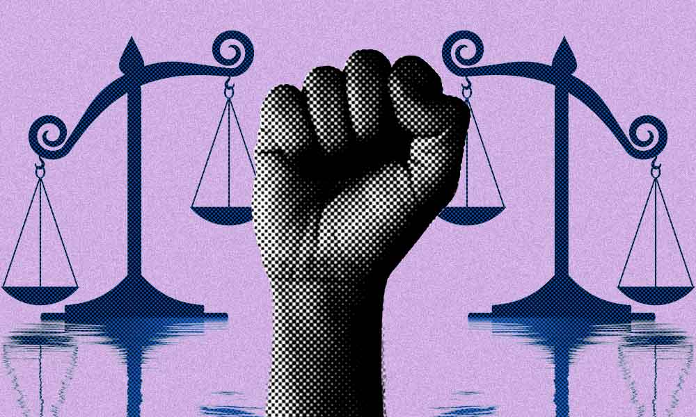 raised fist between unbalanced scales of justice